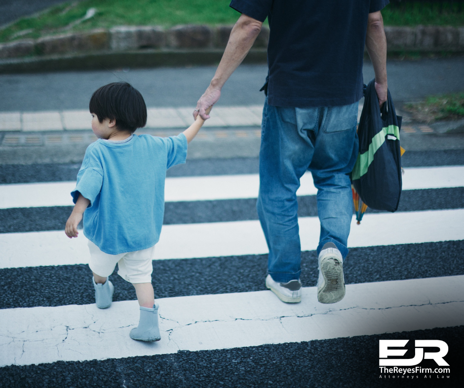 Adult holding a child’s hand while crossing a crosswalk, representing pedestrian safety on Tampa neighborhood streets.