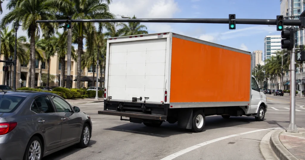 Generic rental moving truck making a wide turn near a passenger car at a Tampa intersection, for illustrative purposes only.